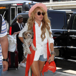 Paulina Rubio holds her dog as she arrives at LAX