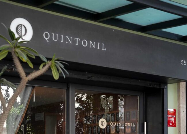 Quintonil celebrará su 14° aniversario el próximo sábado 7 de marzo con un evento gastronómico exclusivo que reunirá a dos figuras prominentes de la escena culinaria contemporánea. La conmemoración incluirá un servicio único, solo disponible en esa fecha, donde el chef Jorge Vallejo colaborará con el chef danés Nicolai Nørregaard, del restaurante Kadeau en Dinamarca, mostrando así las razones de las encomiables reseñas que ambos establecimientos han recibido. Esta colaboración ha levantado grandes expectativas entre críticos y amantes de la gastronomía, especialmente por la admirable trayectoria de ambos restaurantes, ampliamente reconocidos en diversas opiniones internacionales que destacan su enfocada conexión con el territorio, técnicas innovadoras y su narrativa culinaria cautivadora. Este evento se posiciona como uno de los hitos gastronómicos más importantes del año en la Ciudad de México. Un menú excepcional de cuatro manos con visión global y reseñas especializadas El menú que se presentará en esta jornada será el resultado del trabajo conjunto entre Vallejo y Nørregaard, una dinámico que Quintonil ha mantenido en sus celebraciones anuales. A través de estas alianzas, el restaurante mexicano se ha establecido como un punto de referencia para la gastronomía global, fomentando el diálogo cultural y la creatividad. Nørregaard es reconocido como uno de los principales exponentes de la cocina postnórdica, un movimiento que reinventa la tradición desde una perspectiva contemporánea. Su oferta en Kadeau, que cuenta con dos estrellas Michelin en Copenhague y una en Bornholm, se basa en ingredientes locales, forrajeo, técnicas de conservación y el uso de métodos de ahumado tradicionales, elementos que han obtenido elogios en varias reseñas por su equilibrada combinación de rusticidad y sofisticación. Quintonil, un símbolo respaldado por su prestigio y valoración La celebración del aniversario tiene lugar en un momento crucial para Quintonil, que es considerado uno de los restaurantes más influyentes a nivel mundial. Actualmente, ocupa el tercer lugar en The World’s 50 Best Restaurants, posee dos estrellas Michelin y, en 2025, se convertirá en el primer restaurante mexicano en integrar Les Grandes Tables du Monde, un reconocimiento que resalta su excelencia en la gastronomía y calidad de hospitalidad. Más allá de los galardones, Quintonil ha construido su prestigio a lo largo de un trayectoria sólida, respaldada por reseñas y opiniones en redes sociales y plataformas especializadas, que lo describen como un “archivo vivo” de la biodiversidad mexicana. Bajo la dirección de Jorge Vallejo, el restaurante expresa los sabores del territorio desde una perspectiva contemporánea, incorporando ingredientes locales, técnicas tradicionales y un firme compromiso con la sostenibilidad. La experiencia en Quintonil se complementa con un modelo de hospitalidad liderado por Alejandra Flores, quien se caracteriza por su atención cercana y personalizada, así como por su compromiso en la formación de nuevas generaciones de talento y su participación en iniciativas filantrópicas internacionales, como su colaboración con la Fundación Uccelin. Quintonil, fundado en 2012, es un referente del proyecto culinario de Alejandra Flores y Jorge Vallejo, cuyo objetivo es retratar en su menú los sabores de los ingredientes del territorio mexicano desde una mirada personal y contemporánea. Desde su ubicación en Newton 55, Polanco, Ciudad de México, el restaurante se ha consolidado como uno de los máximos referentes de la alta cocina, tanto nacional como internacional. Por ello, se recomienda seguir de cerca sus canales de reservación para no perderse esta experiencia excepcional.